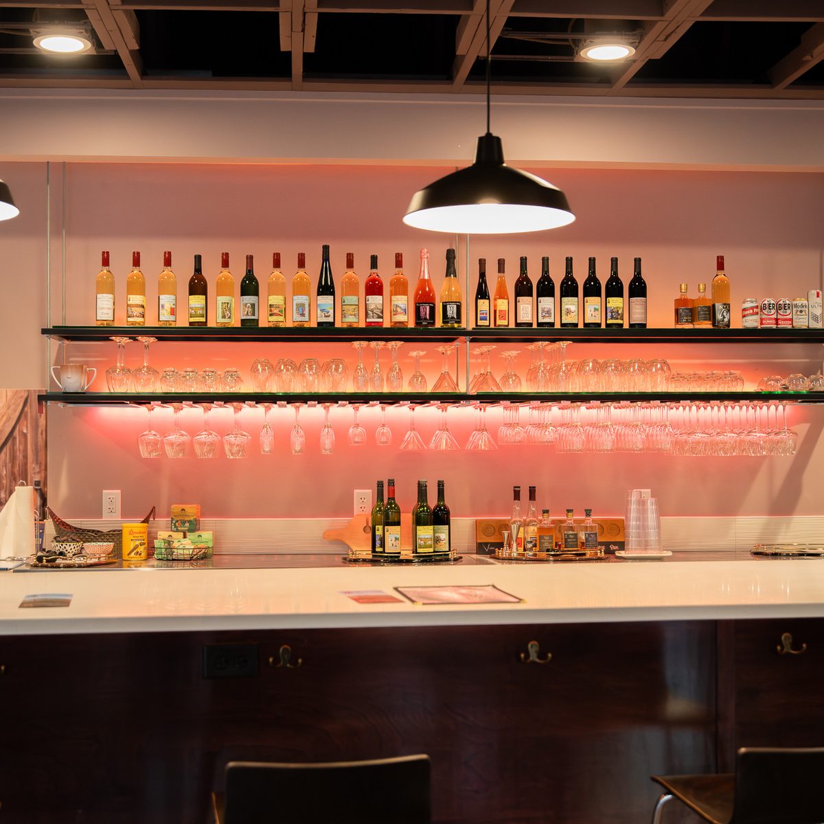 Bar area at NYX Spirits & Lounge with wine, spirits, glassware, and warm lighting.