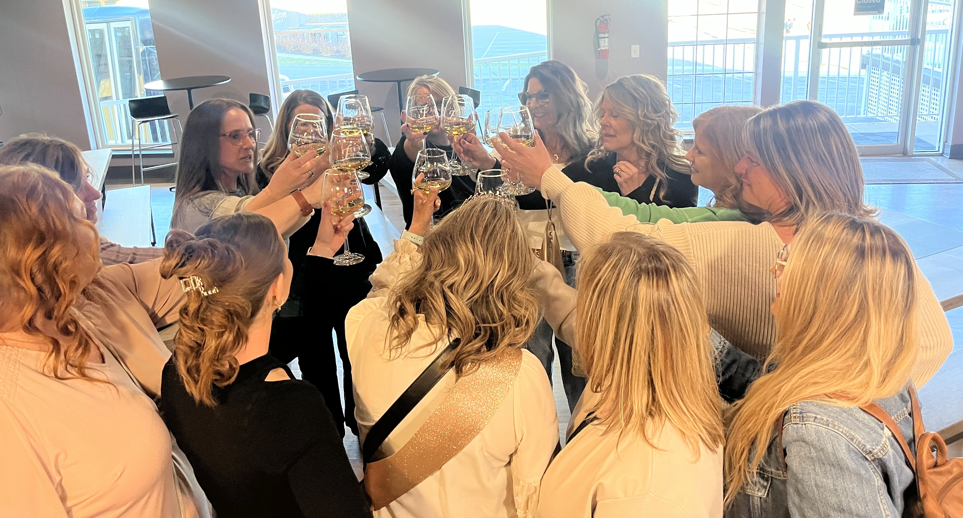 Group raising glasses during happy hour at NYX Spirits & Lounge