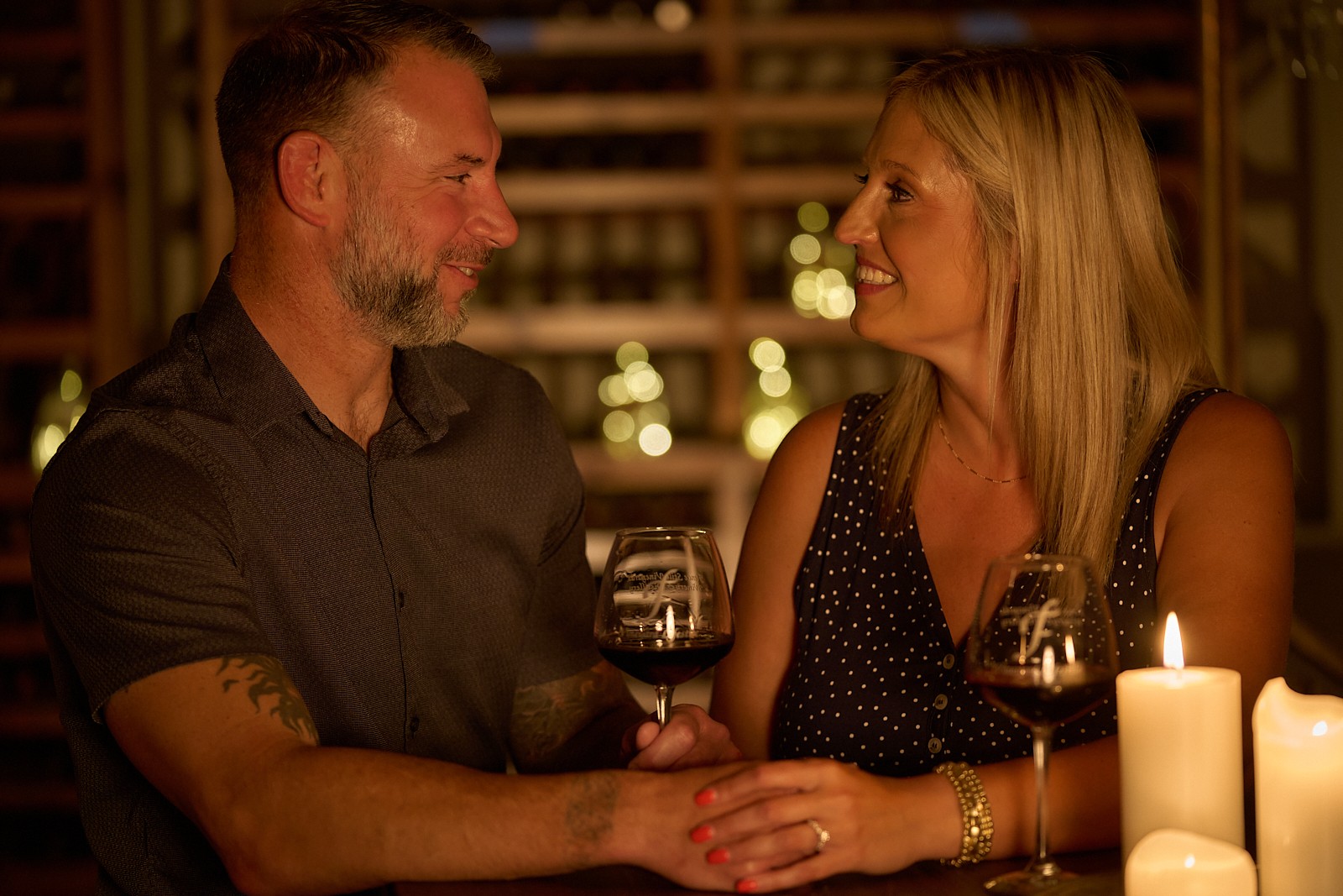Candlelit wine glasses on a table at NYX Spirits and Lounge in Gladstone Missouri — a relaxed date night setting